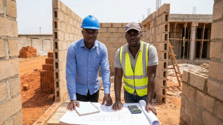 Maître d'ouvrage inquiet examinant le budget sur un chantier en Côte d'Ivoire
