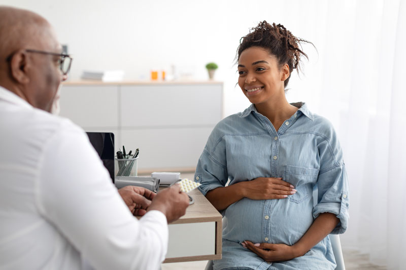 Enceinte africain femme a rendez-vous avec médecin à clinique. Masculin  gynécologue ob gynécologue médical spécialiste